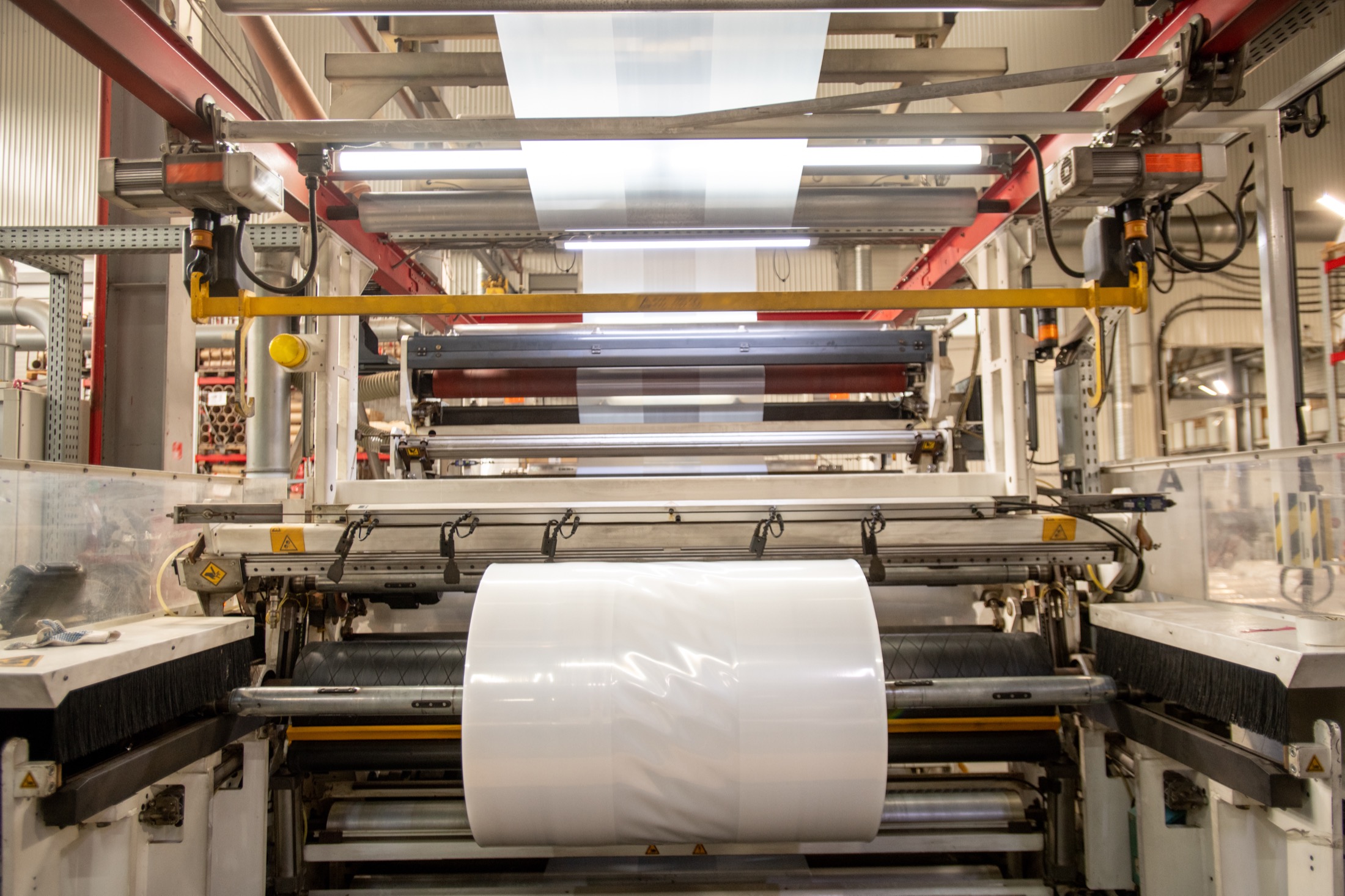 Rotoli e film plastico in lavorazione su macchinario industriale
